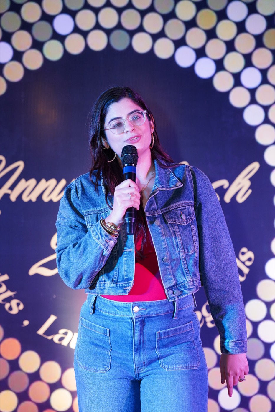 Mehak Madan performing stand-up comedy, mic in hand